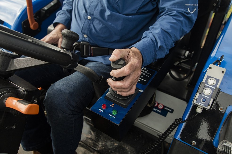 Trator adaptado tem controle de plataforma de embarque e desembarque e comandos de cabine reconfigurados — Foto: New Holland