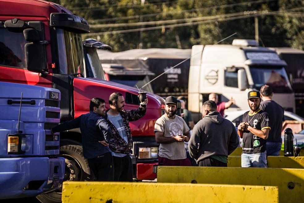 Enquanto aguardavam o momento de descarregar a soja, caminhoneiros mantinham carretas estacionadas em posto de combustível — Foto: Marcelo Curia