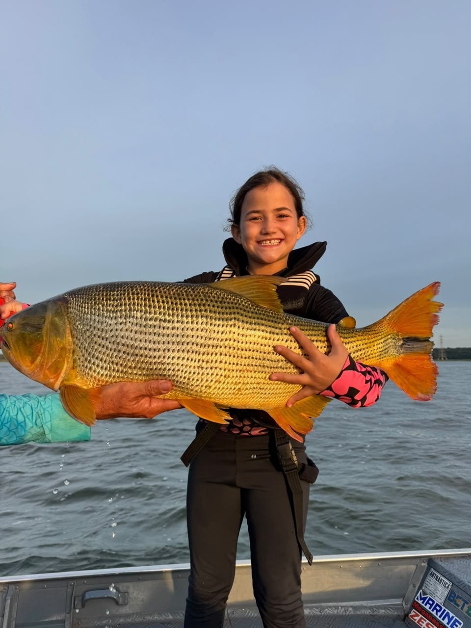 Menina de sete anos quebra o próprio recorde ao pescar dourado gigante